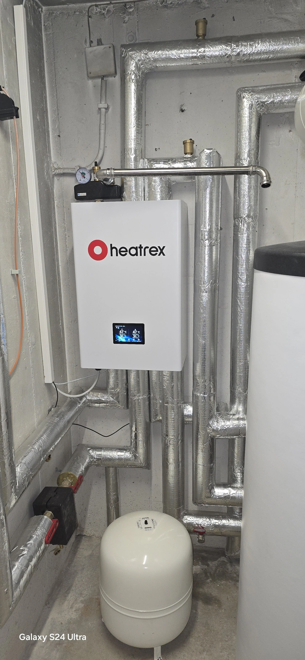 Pompy ciepła powietrze woda zainstalowana w kotłowni z izolowanymi rurami i zbiornikiem wyrównawczym