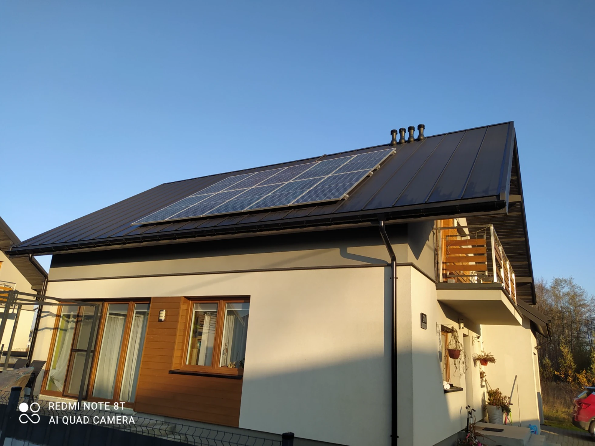 Dach nowoczesnego domu z zamontowanymi panelami fotowoltaicznymi